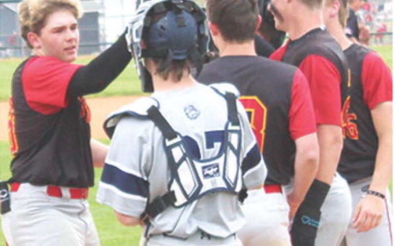 Kash Smith, Titan Freshman, is congratulated at home plate by his teammates following his third inning, base clearing, home run in his first varsity start for the Titans. The hit was Kash’s second grand slam of the game, tying a state record for most grand slams in one game. A single in the fourth inning gave Smith a total of nine Runs-Batted-In in the 14-1 win over the Bulldogs in Galena, Monday. Columbus completed the sweep with a 10-0 win in game two.
