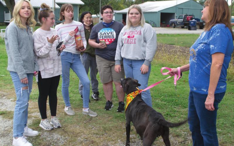 Riverton High School Teacher Margaret Radlund holds a dog by the leash before her FCCLA students, Katie Burge, Karli King, Joanna Lewis, Elizabeth Feldcant, Andy Jones, and Bailee Riggs. The dog is seen wearing a bandana that one of Radlund’s other classes had made for the animals beforehand. Photo by Jacob Spencer.