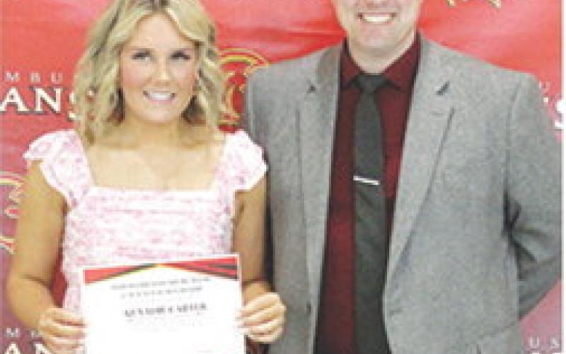 Kenadie Carter received a $250 Harold Brandenburg Math and Science Scholarship from USD 493 Math Instructor, Luke Henke, during the 2025 Senior Assembly at the CUHS Gymnasium, May 16.