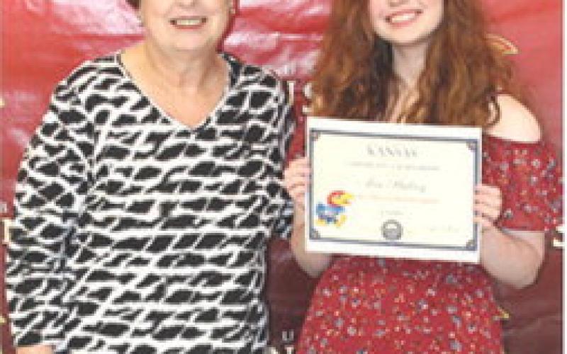Senior Ava Hulvey received a $20,000 University of Kansas Chancellor Scholarship from CUHS Instructor, Karen Langerot, during the 2026 Senior Assembly at the Columbus Unified High School Gymnasium, May 15.