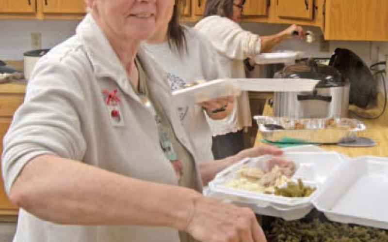 Dipping green beans kept Debbie Messer busy Saturday morning first in the to go orders then serving those present at the Annual Community dinner.
