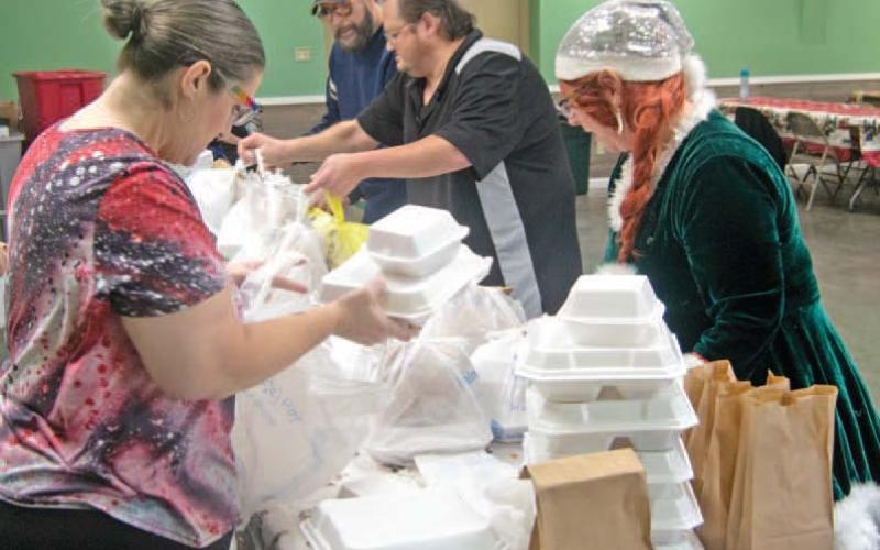 Volunteers prepare Christmas dinners for delivery to those unable to attend the Annual Community dinner at the 4-H building.