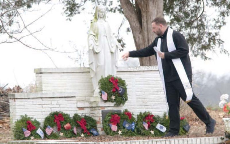 Blessing the Wreaths across America, Father Chris Martin attended the placing of the wreaths and blessed each one at the grave site.