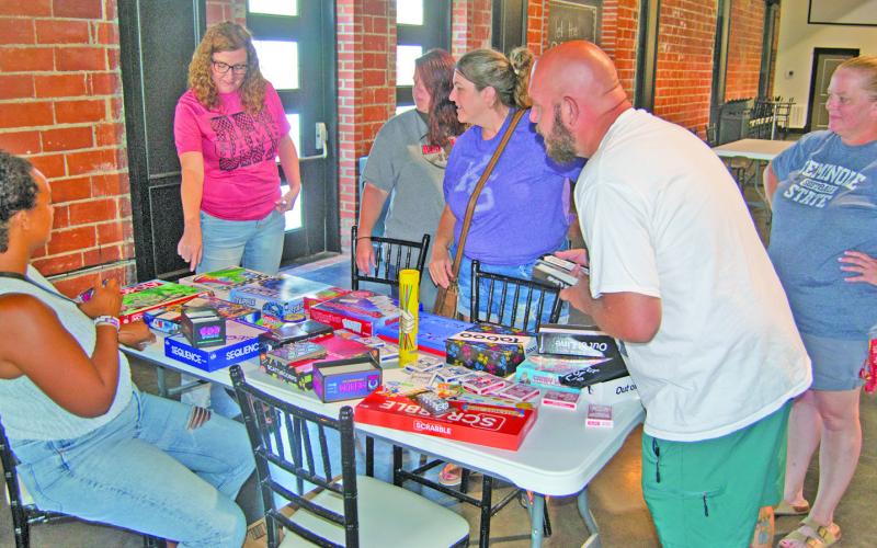 The Columbus Library sponsored Game Night drew families to play several games. The event held at the State Theatre Event Center. Librarian Lauren Dainty hands out games to the players.