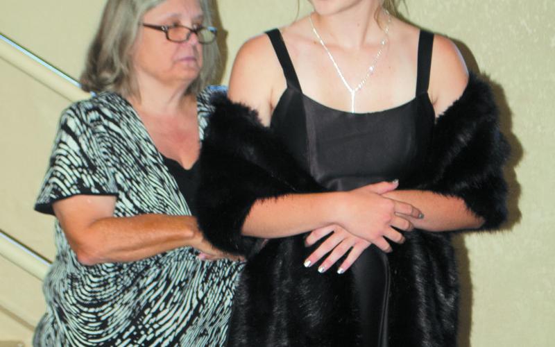 Judge Susie Carrington takes a closer look at the formal outfit modeled by Zoie Elmore at the Style Revue held July 15 at Columbus First Christian Church