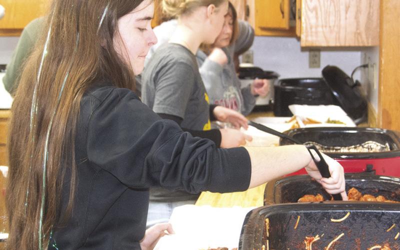 During the recent spaghetti dinner fundraiser for Eva Maxton, Kora Welch was helping out in the kitchen. She was boxing up spaghetti and meatballs for those attending. News Report photo by Shawn Churchill.