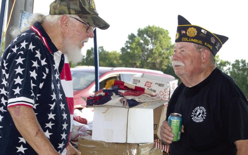 Larry Crozier and Homer Wayne Dobkins were discussing the flags that had been brought to the POW/MIA Watchfire for the retirement ceremony.