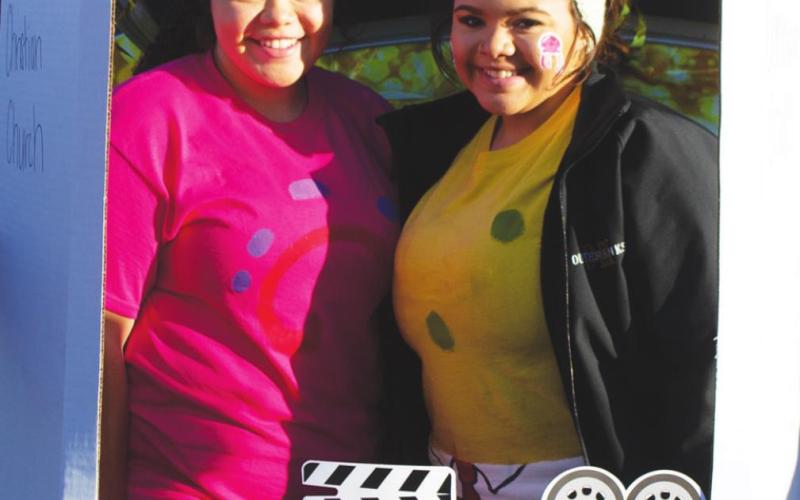 First Christian Church of Columbus members Destiny Lima and Erin Lima pose at their display’s Hollywood-themed photo booth at this year’s Trunk or Treat. The design was quite popular with the crowd, allowing people of all ages to take unique pictures at the setup. Photo by Jacob Spencer