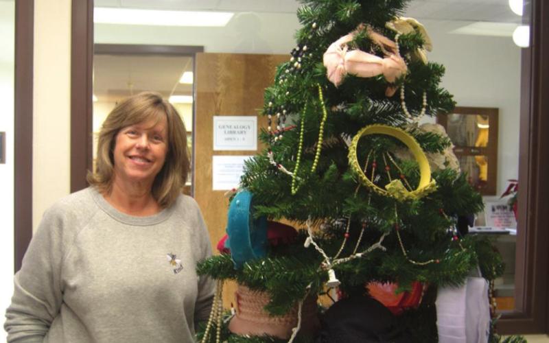 Various hats, caps, crowns and tiaras were adorned all over the Columbus Museum’s Christmas tree for the month of May. The location’s workers make specific efforts to decorate the tree in unique ways each and every month. Patti Street shows off one of its decorative sides. Photo by Jacob Spencer