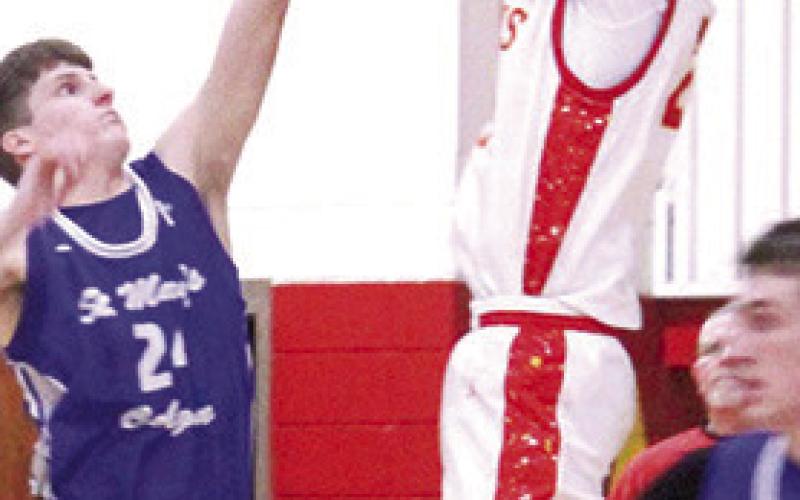 Titan Junior, Kooper Saiz, shoots for two points over the outstretched arms of St. Mary’s-Colgan Sophomore, Gabe Brown, in the Columbus homecoming loss to the Panthers, 48-78, Friday at the CUHS Gym. Kooper had ten points for the Titans.
