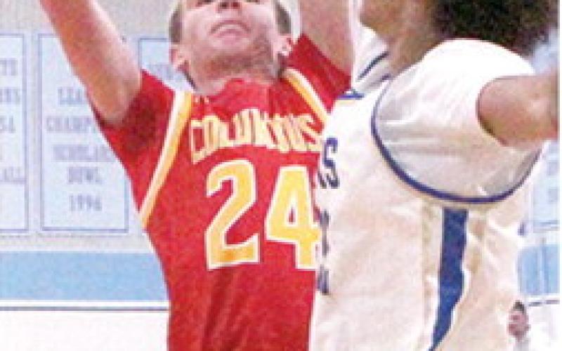 Kooper Saiz, Titan Sophomore, goes up against a towering, Terryk Richardson, Riverton Senior, on his way to scoring 17 points for Columbus in their first round Lancer Classic loss, Monday, in Cherokee.