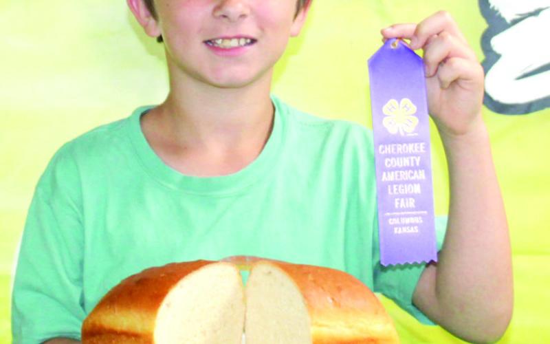 Hunter Davis shows his purple ribbon and his loaf of bread he entered into the Cherokee County foods show.