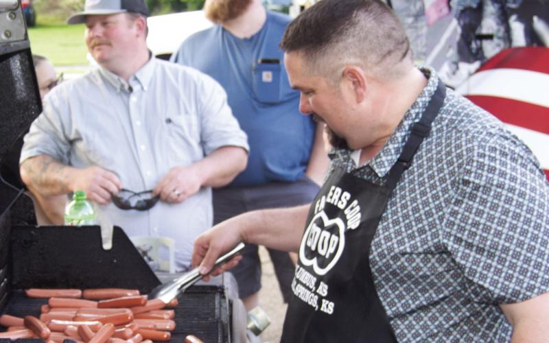 Preparing for the hot dog eating contest Matt Case, manager of the Cherokee County Farmers Coop, was at the grill. Hundreds of the tasty treats were prepared for the contest and the free hot dogs were provided by Moates Excavating for the Cowtown Days in Baxter Springs.
