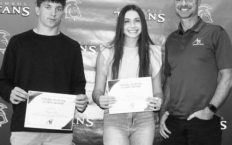 Kayden Cox and Faith Henry each received a $1,000 American Bank Scholarship from Bank Vice President, Jim Gaither, during the Columbus Unified High School Senior Assembly, May 19, in the high school gym.