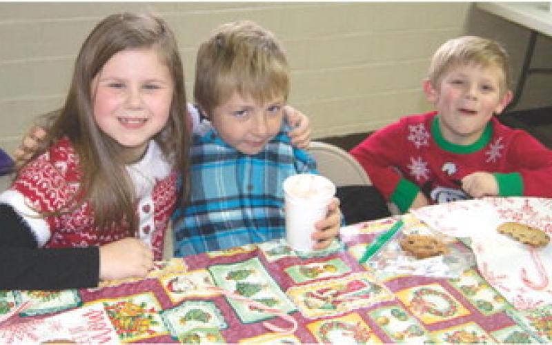 After the annual Scammon Chistmas parade, youngsters had the opportunity to have cookies and hot cocoa. Maya Holcombe, Daniel Madl and Landon Holcombe joined in the fun.
