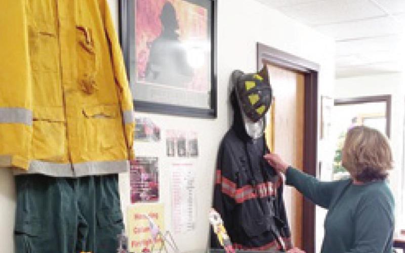 The Columbus Museum has begun a new display that will honor various organizations throughout the year. The first display features the local Fire Department. With the assistance of Fire Truck Driver Jaden Tedlock, the display is ready for viewing. Museum volunteer Patti Street makes a minor adjustment to the display. The display will be available for viewing throughout the month of May.