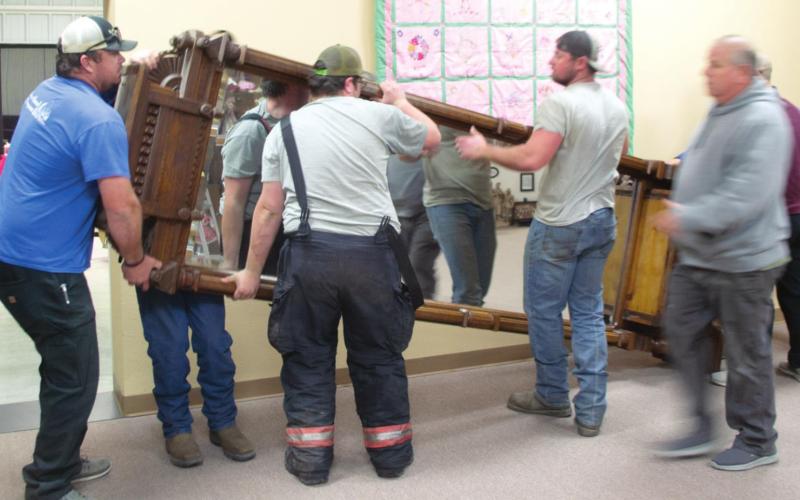 A team of movers helps to transport a mirror that was donated to the Columbus Museum by Wes and Jan Houser last month. Up to six men at a time carried the heavy object out of the Housers’ old home, into and out of a moving truck and to its final destination across town. Photo by Jacob Spencer