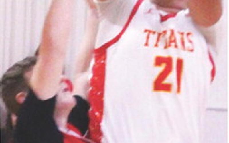 Titan Senior, Rece Ponce, went up for two points over his Baxter Springs opponent, in the 38-60, Titan loss to the Lions, Friday, at the Columbus Unified High School Gymnasium.