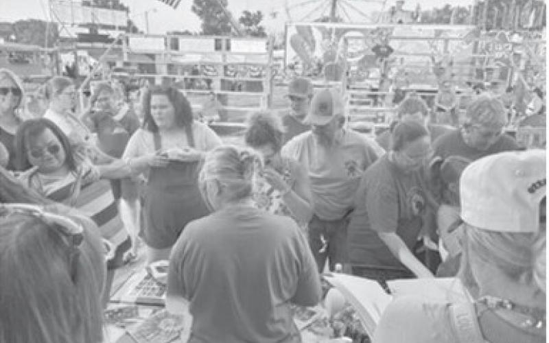 Former students of Greenlawn Elementary School gathered around the bandstand Wednesday at the fairgrounds. They were looking at all the items recovered from the time capsule that was recently opened. Courtesy photo.