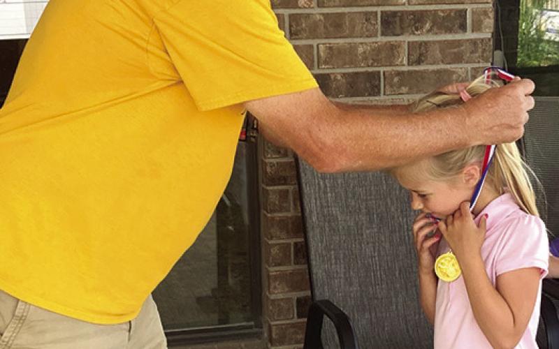 the 6-8 year-old age group following the junior golf tournament in Parsons, Thursday. Courtesy Photo. Caroline Scammon received her first place medal in