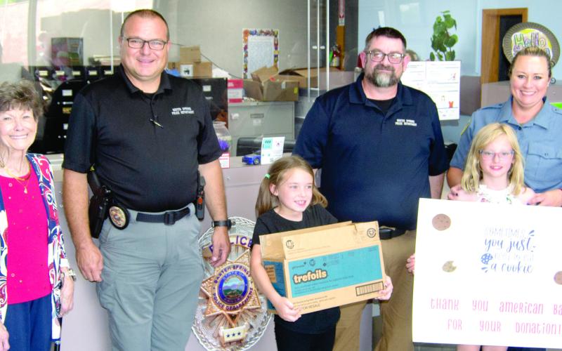 The Baxter Springs Girl Scouts received a helping hand from American Bank as the bank purchased several cases of Girl Scout Cookies which had gone unsold. The girls then delivered the cookies to the Baxter Springs Police Department as a thank-you to the men and women in the department. American Bank vice-president Judy Hill was joined by Girl Scouts Kinley Capps and Sutton Russell as they presented the cookies to Police Chief Brian Henderson, and officers Jimmy Hamilton and Rhanda Andrews.