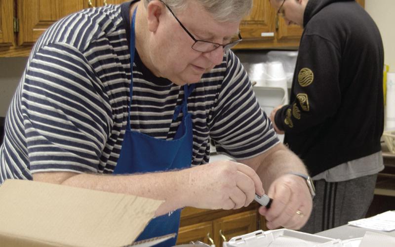 Mayor Grant Spieth prepares call in orders received at the Lions Club bean and soup feed held at the St. Rose Parish Hall March 5.
