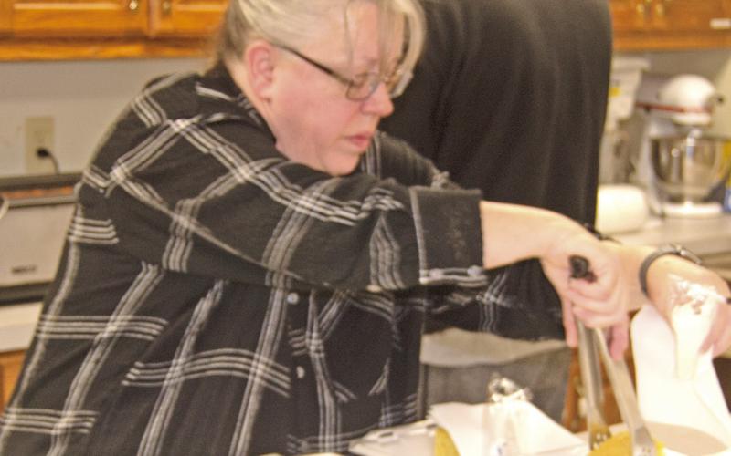 Janet Lindsey is preparing orders at the Lions Club Bean feed held March 5. Bean feed photos byTanya Woolsey.