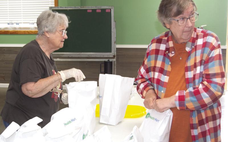 Linda Garrison and Cheryl Vanatta were bagging to go orders at the fundraiser for Jenny Shilts recently. News Report photo by Tanya Woolsey.