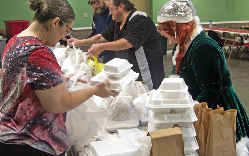 Volunteers prepare Christmas dinners for delivery to those unable to attend the Annual Community dinner at the 4-H building.
