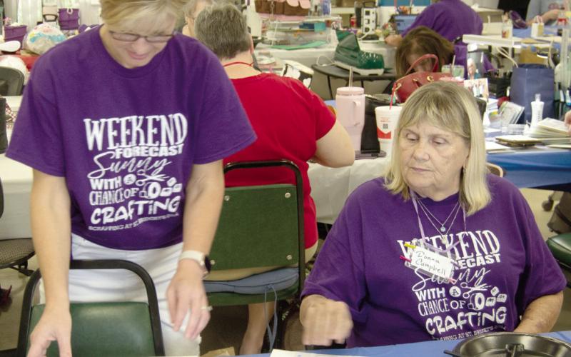 Kristi Fintner and Donna Campbell discuss photo placement on the page of a scrapbook. Everyone seems to be happy to offer advice when someone has a question.