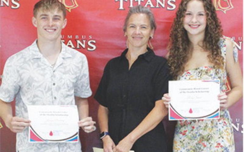 Korbyn Newberry and Ruby Stover received Community Blood Center of the Ozarks Scholarships in the amount of $150 each from USD 493 Instructor, Brandy Pierce during the 2025 Senior Assembly, May 16, at the Columbus Unified High School Gymnasium.