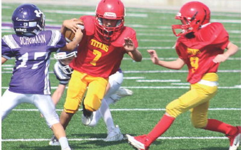 Mini Titan Briggs Johnson gets a block from Bodie Saiz on his way to the end zone for six of the 22 Columbus points scored in the victory over Pittsburg Ryan, 22-0, Saturday, at Hutchinson Field in Pittsburg. Courtesy Photo.