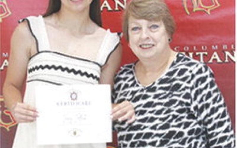 Torey Tedlock received the Wyandotte Nation Tribal Scholarship for $40,000 from USD 493 Instructor, Karen Langerot, during the 2025 Senior Assembly at the CUHS Gymnasium, May 16.