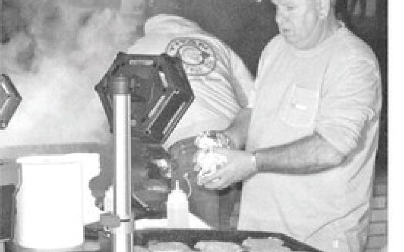 Among the many activities planned for the Christmas Celebration Wednesday, December 4, are (above) the tree lighting by the Lions Club and (below) burgers cooked by Columbus fire fighters.