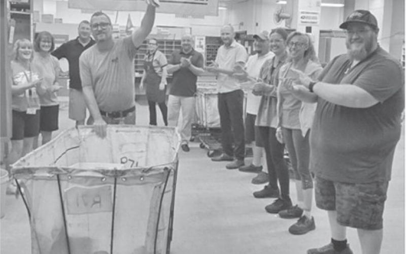 Pat York participates in the traditional “running of the gauntlet” at the Columbus Post Office. York is retiring after 26 years of service. Co-workers lined up to congratulate York on his accomplishments and to wish him well in his future endeavors. Courtesy photo.