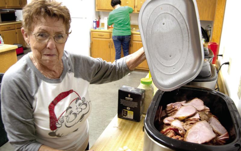 In addition to turkey and all the trimmings, the Community Christmas dinner offered ham as a component. Donna Pace was placing the ham on the plates.