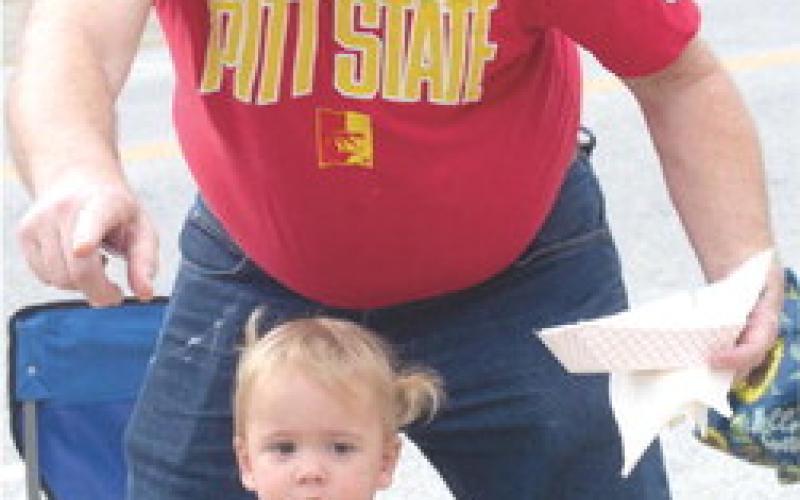 Elinore Phillips proudly wearing her 2023 Weir Homecoming shirt at the Homecoming Parade as her grandfather attempts to get Elinore to look at the camera.