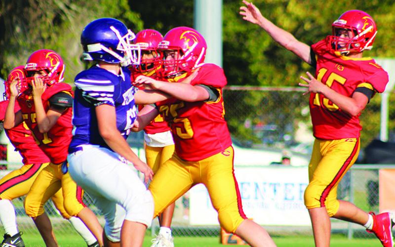 Titan Jex Cheney, and members of the seventh grade offensive line give quarterback, Jace Gaither, time to throw during the 28-34, Titan loss to Pittsburg, Monday, at Titans Stadium. The non-conference thriller ended in an overtime standoff won by the visiting Purple Dragons.