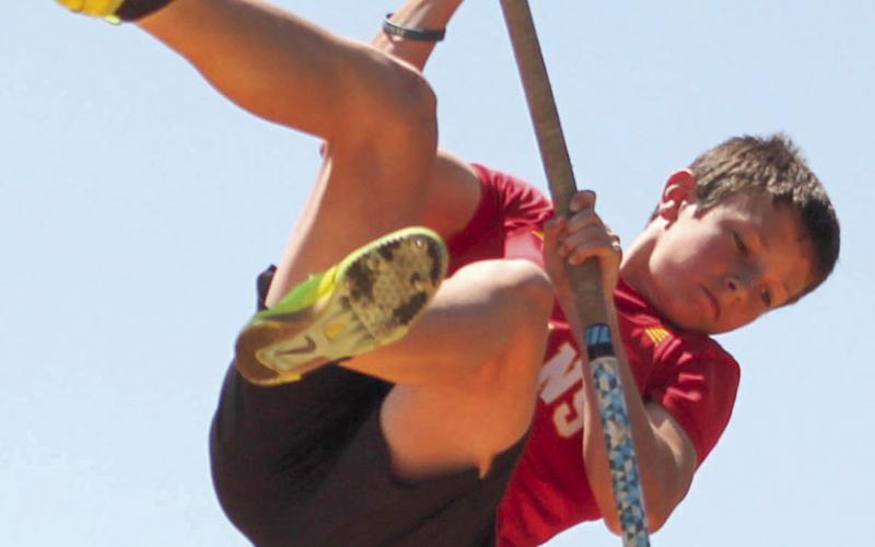 Tanner Scott (left) clears the bar for a new school record in the eighth grade boys pole vault with a height of 9’7” at the Columbus Invitational Meet, Monday. The previous record was set in 2022 by Jayden Rodriguez with a height of 9’6”.