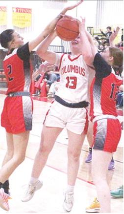 Lady Titan Senior, Trinity Green, goes up for a basket between the outstretched arms of senior, Mya Vestal and junior, Layla Weaver, in the 39-20, Columbus win, Tuesday, at the CUHS Gymnasium.