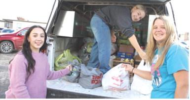 Hannah Noel, Amory Neely and Morgan Richards helped unload groceries to be placed in the Thanksgiving meal boxes. The boxes were distributed Tuesday before Thanksgiving.