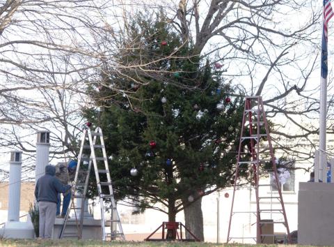 Columbus Lions Club members harvested a tree for the Courthouse on Sunday afternoon. With help from the Fire Department, the tree was raised in place and decorated. Lights were strung on the tree by Lions Club members.