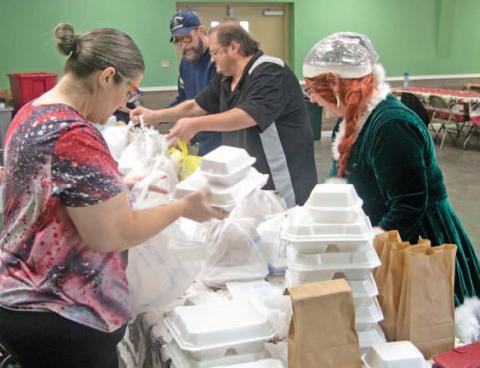 Volunteers prepare Christmas dinners for delivery to those unable to attend the Annual Community dinner at the 4-H building.