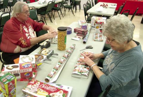 Preparing gifts for the Ugly Holiday Sweater contest winners were Steve Langerot and Donna Renn. The sweater show was held Sunday evening at St. Bridget’s Parish Hall.