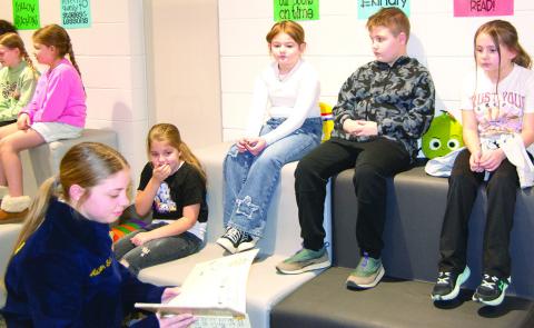 During FFA week at Columbus High School Addison Seitz reads to Verona Anderson, Piper Robinson, Trigger Allen and Ellie Skahan from Caitlin Creech’s third grade class at Central Elementary. Reading took place at the Central Elementary Library as part of FFA week. News Report photo by Tanya Woolsey.