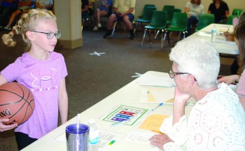 Reagan Holmes excitedly shows the judges her basketball outfit for the active wear category and explains to Dorothy Holmes about her outfit during the judging.