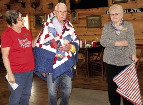 George Kasten (center) was recently honored with an early 90th birthday party. While his birthday is in December, the party was held early so his family in Wisconsin could be present. Kasten was also presented with a Quilt of Valor for his military service at the party. Kathy Lunday and Janie Fletcher presented the quilt.