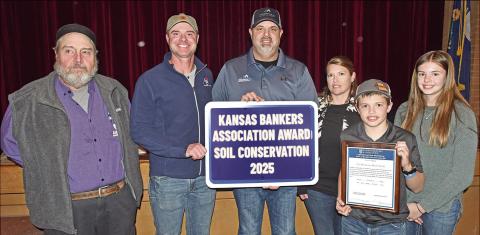 At the Soil and Water Conservation meeting Monday, Nick and Christina Martin and their children Karsten and Kate were presented with the 2025 Kansas Bankers Association Award for Soil Conservation. Mark Epler and Jim Gaither presented the award.
