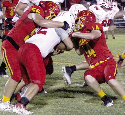 Freshman Kash Smith, the Titans leading tackler, and senior, Brandon Stice, stop Lion Running Back, Sam Weaver, junior, short of the marker creating a turnover on downs late in the Titans win over Baxter Springs, 62-30, Friday at Titan Stadium.