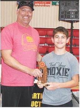 Blaze Bowman receives his Outstanding Wrestler Trophy from Clint Saporito during award presentations at the Sixth Annual Ken Jones Classic Wrestling Tournament hosted by the Columbus Wrestling Club, December 22, at the CUHS Gymnasium. Blaze was also the winner of the 14U, 105-110 pound weight class in the tournament.
